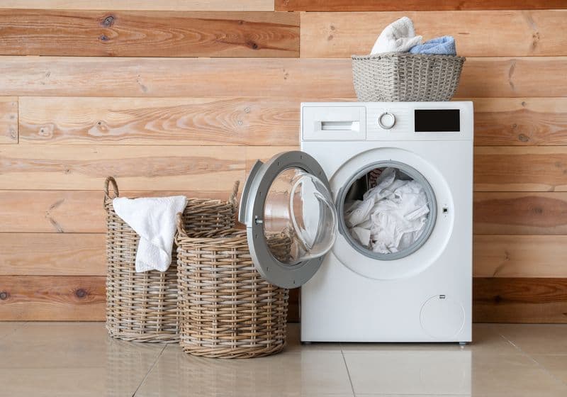 Wasmachine met wasgoed in een lichte bijkeuken